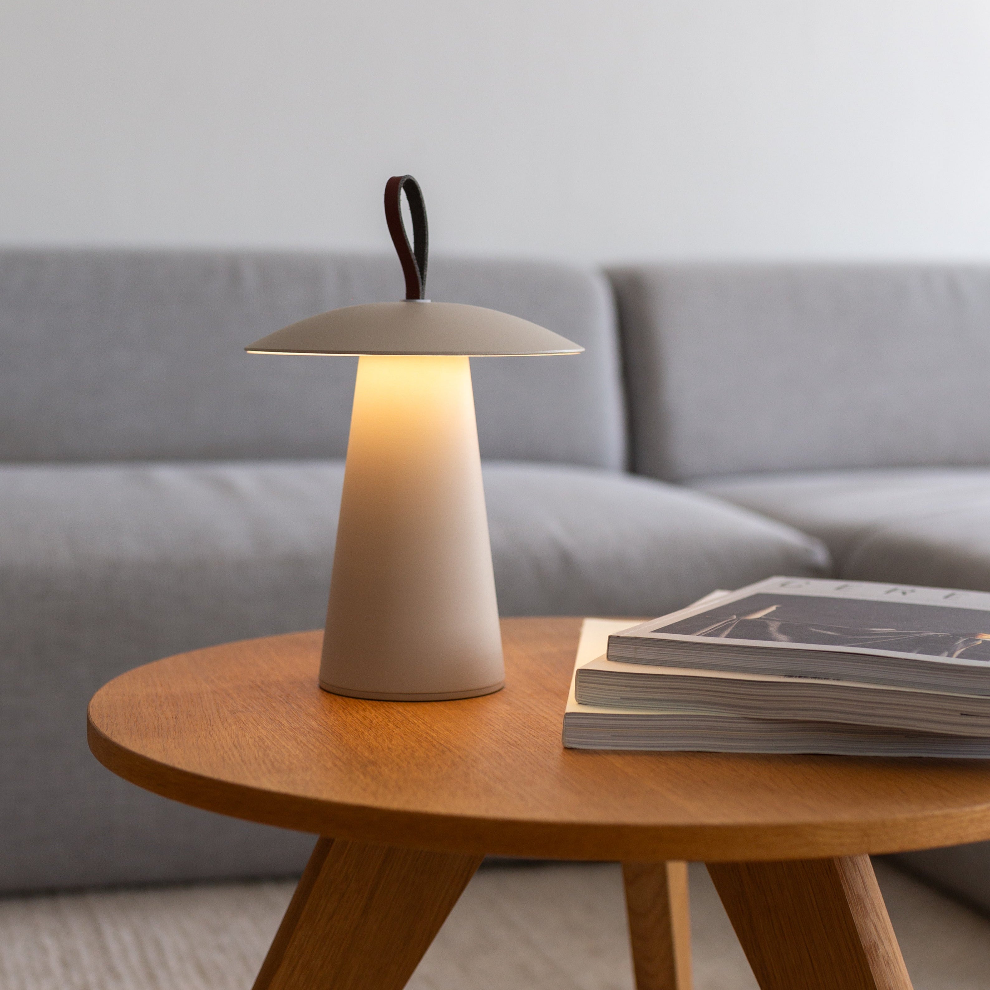 Weiße Beige Lyvo LED-Tischlampe mit Lederhenkel auf einem Holz-Couchtisch – stilvolles, minimalistisches Design für moderne Wohnräume