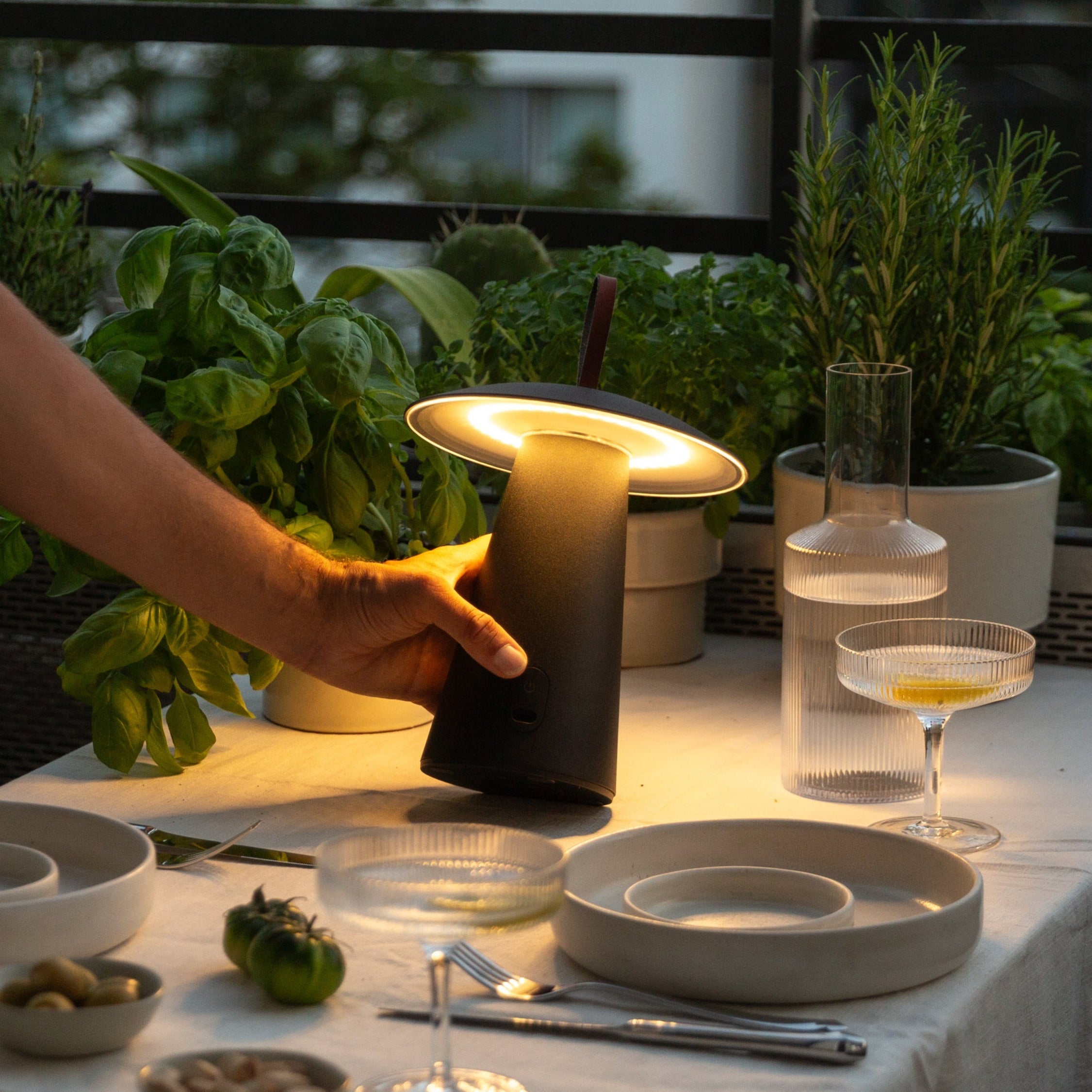 Minimalistische, mobile und kabellose LED Tischlampe mit warmweißen LED Licht auf Balkon