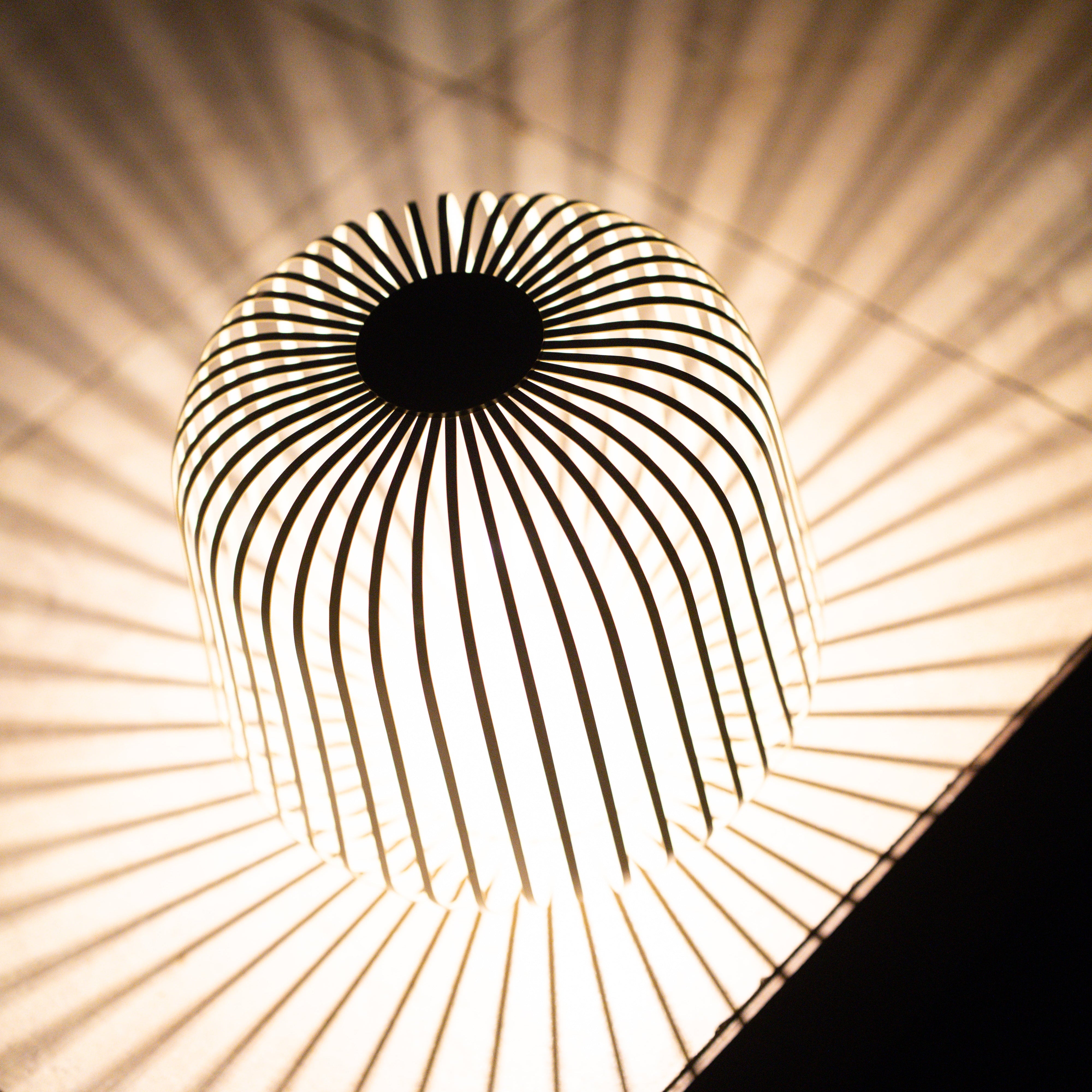 Eine Nahaufnahme der SOLIS Laterne in XXL auf der man den schönen Schattenwurf der Lampe bei angeschaltetem Solarmodul sieht.