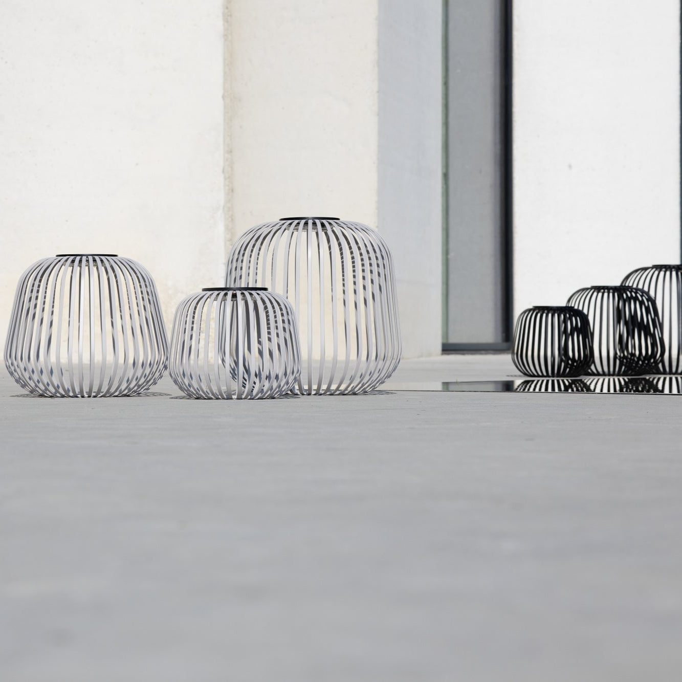 Solis Solarlaternen in drei Größen – modernes Outdoor-Design im minimalistischen Stil vor einer weißen Beton Fassade auf Terrasse