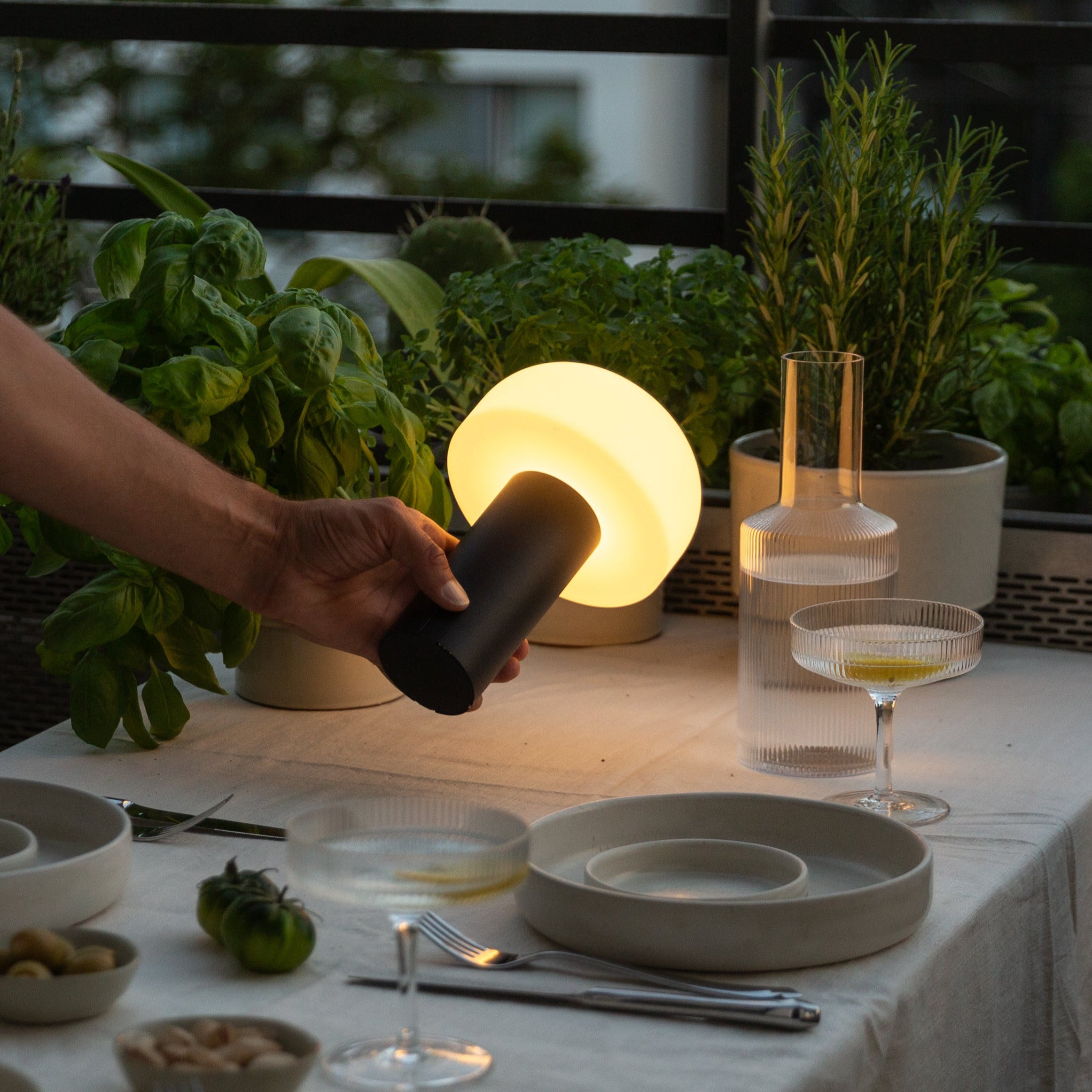 Minimalistische LED-Tischleuchte in Schwarz auf einem Balkon – kabellose, wetterfeste Beleuchtung für stimmungsvolle Abende im Freien