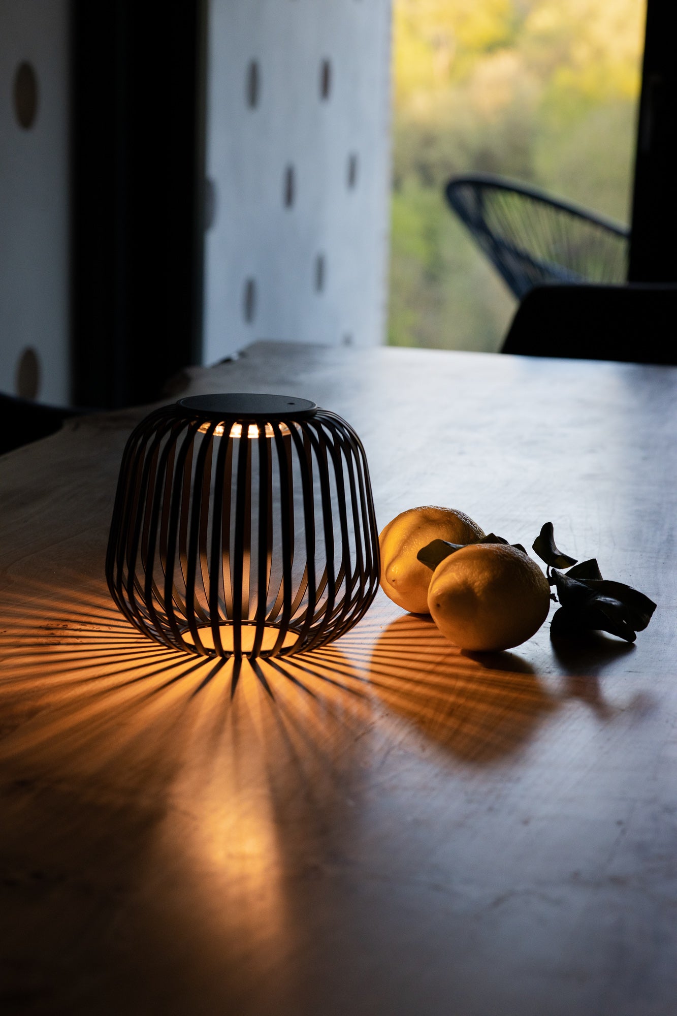 Schwarze Solis Solarlaterne von LUUK Studio auf einem Küchentisch mit stimmungsvollem Lichtspiel, ideal für den Innenbereich