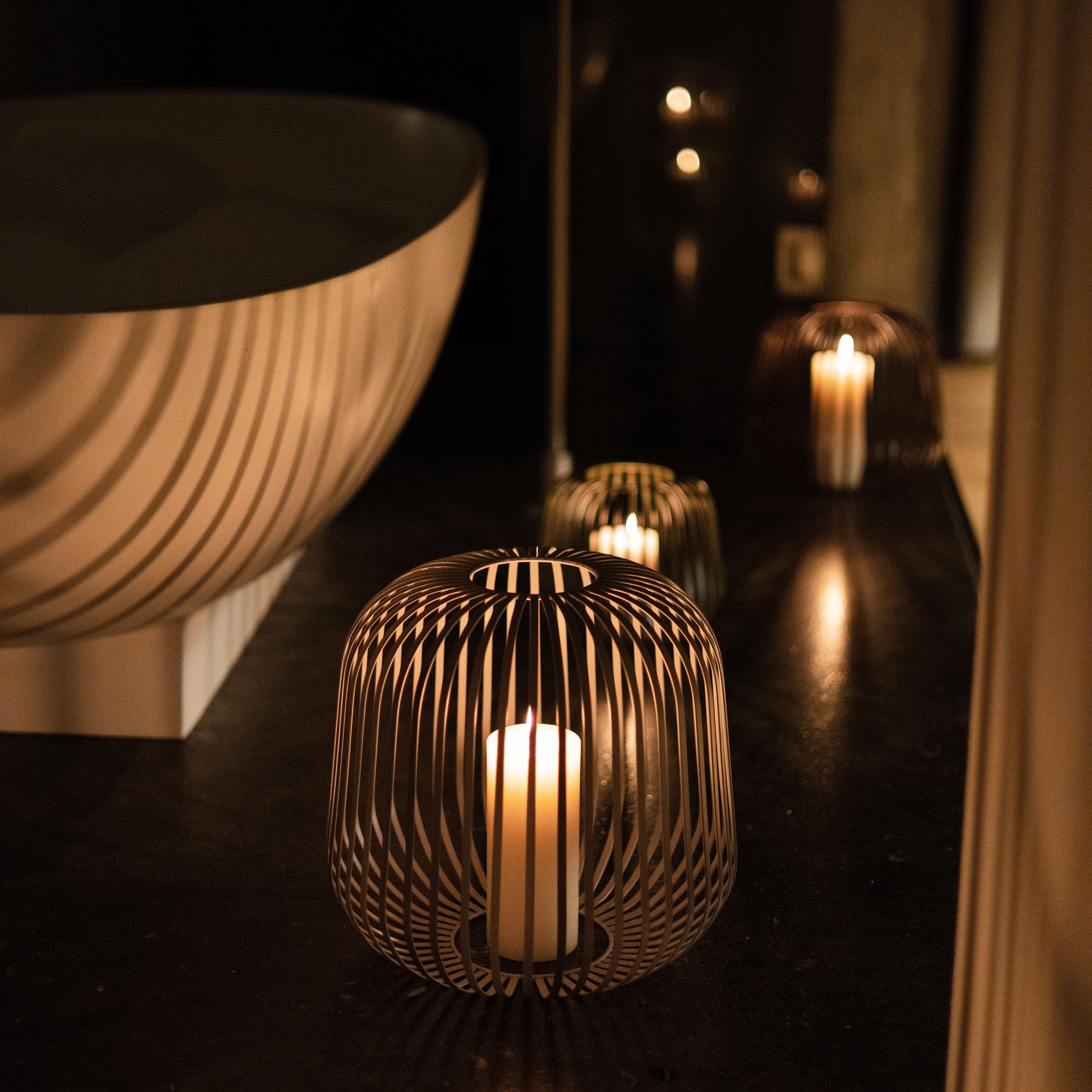 Solis Solarlaterne von LUUK Studio mit eingesetzter Kerze als Windlicht im Badezimmer – stilvolle, warme Lichtquelle für entspannte Momente im Innenbereich.