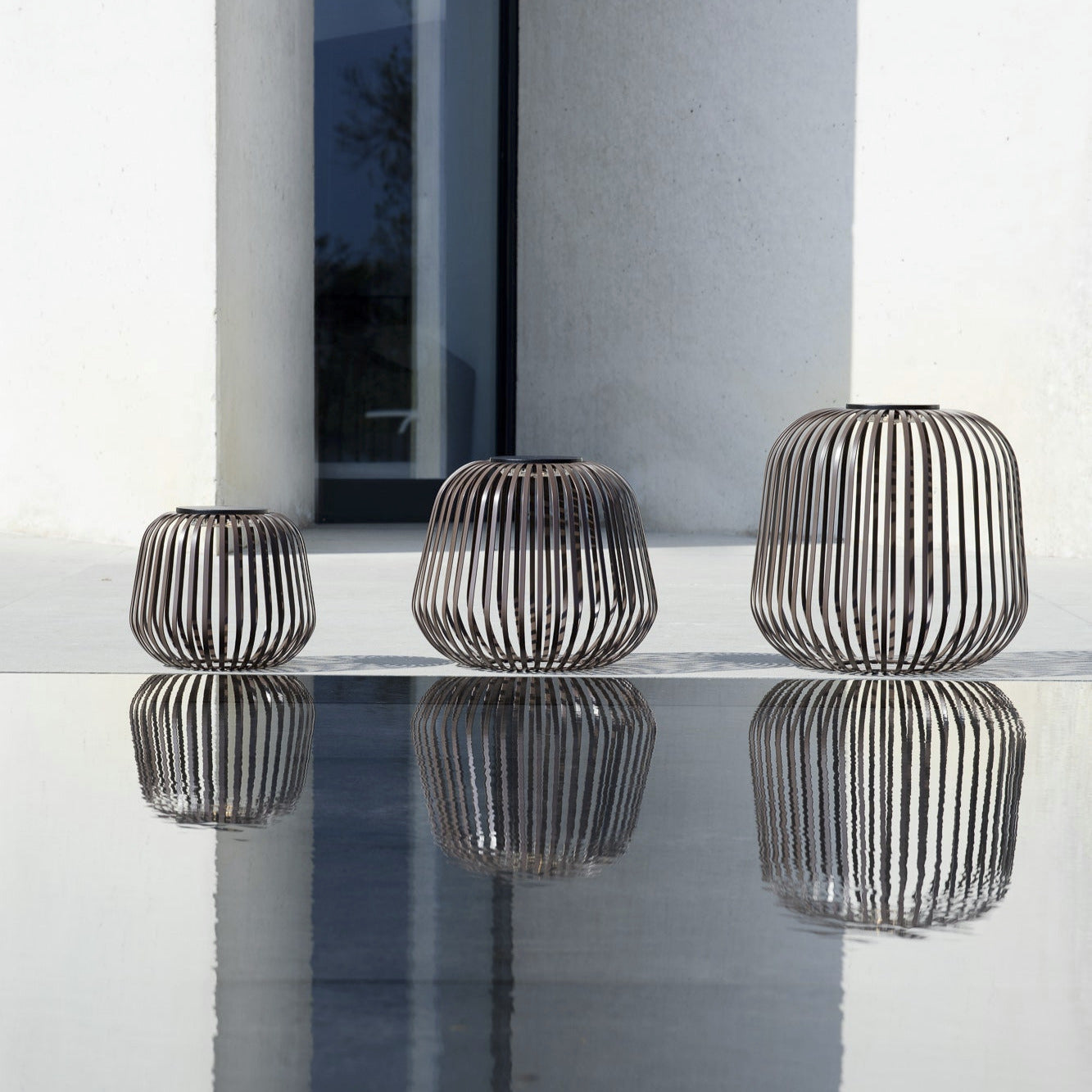 Drei SOLIS Solarleuchten in Walnuss in verschiedenen Größen, modernes Cage-Design, wetterfestes Outdoor-Lichtobjekt mit reflektierender Wirkung – ideal für Terrasse oder Garten