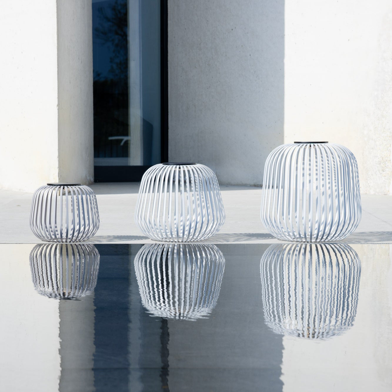 Drei SOLIS Solarleuchten in Grau in verschiedenen Größen, modernes Cage-Design, wetterfestes Outdoor-Lichtobjekt mit reflektierender Wirkung – ideal für Terrasse oder Garten