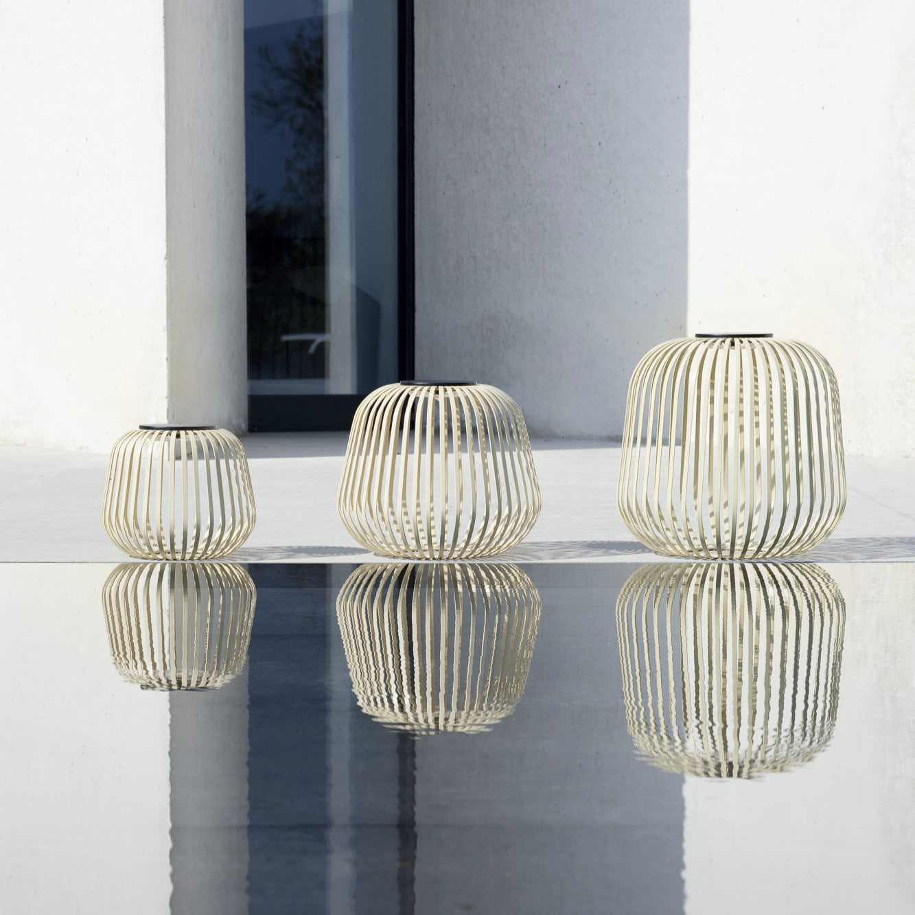 Drei SOLIS Solarleuchten in Sand in verschiedenen Größen, modernes Cage-Design, wetterfestes Outdoor-Lichtobjekt mit reflektierender Wirkung – ideal für Terrasse oder Garten