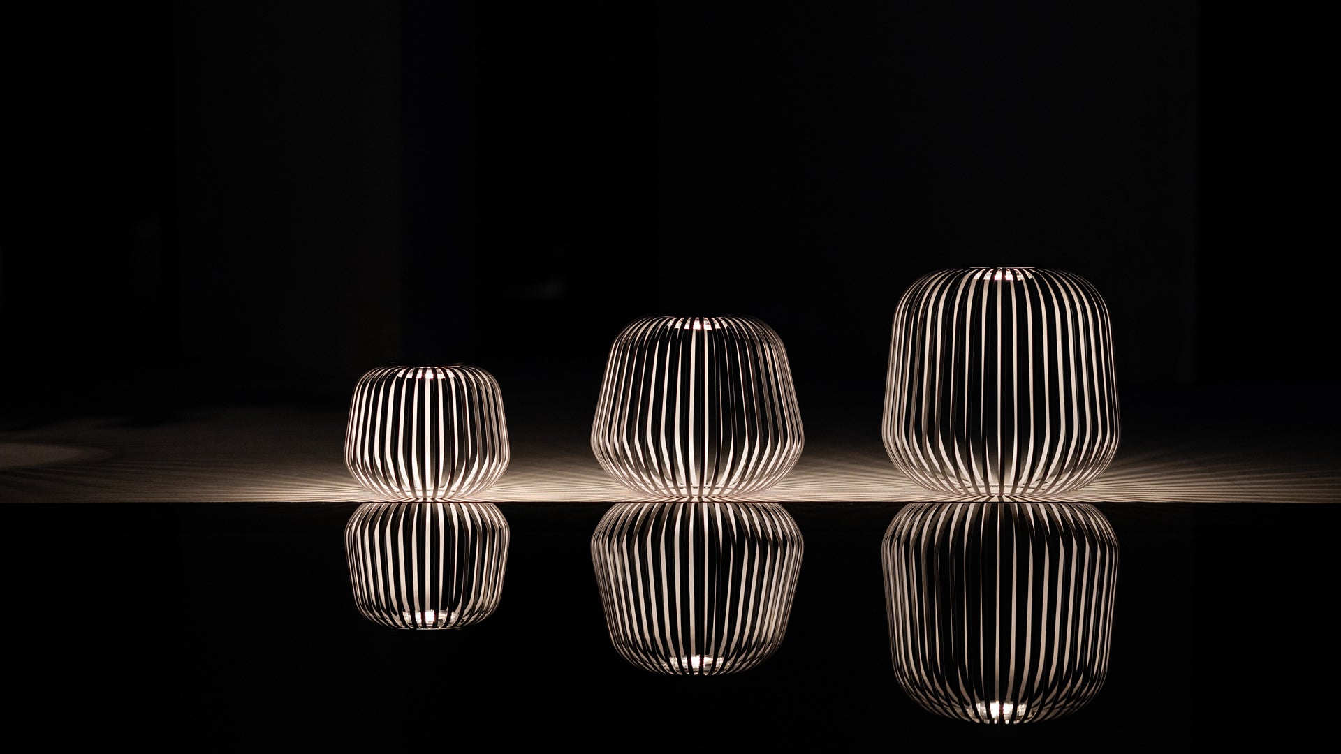 Drei Solarlampen von LUUK Studio mit Licht-Schatten-Effekt und Spiegelung in dunkler Nachtaufnahme