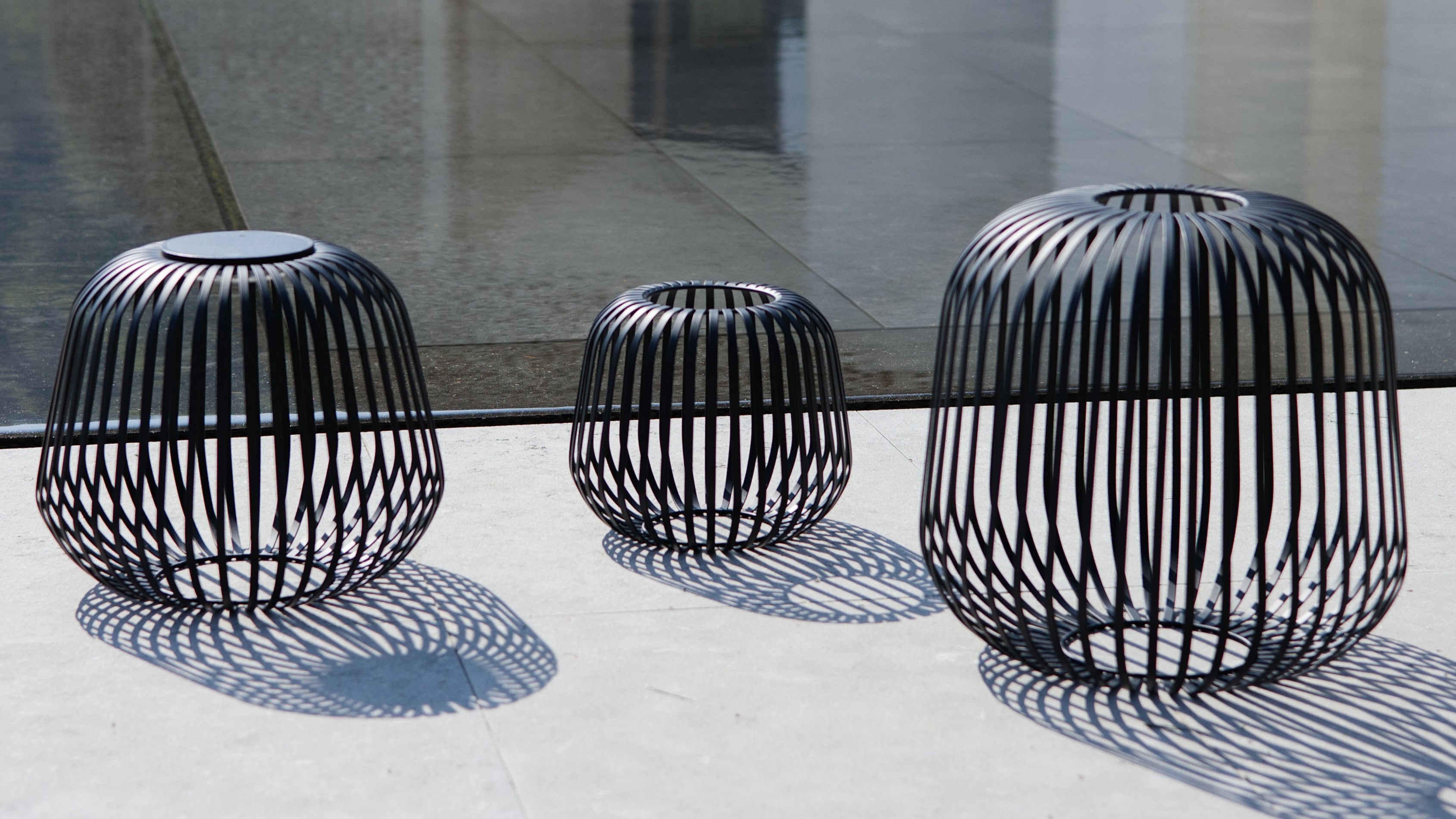 Drei schwarze Solis Laternen aus Metall mit herausnehmbaren Modul bei Tageslicht auf einer Terrasse – stimmungsvolles Outdoor-Licht und stilvolles Windlicht für Garten, Balkon oder Eingangsbereich