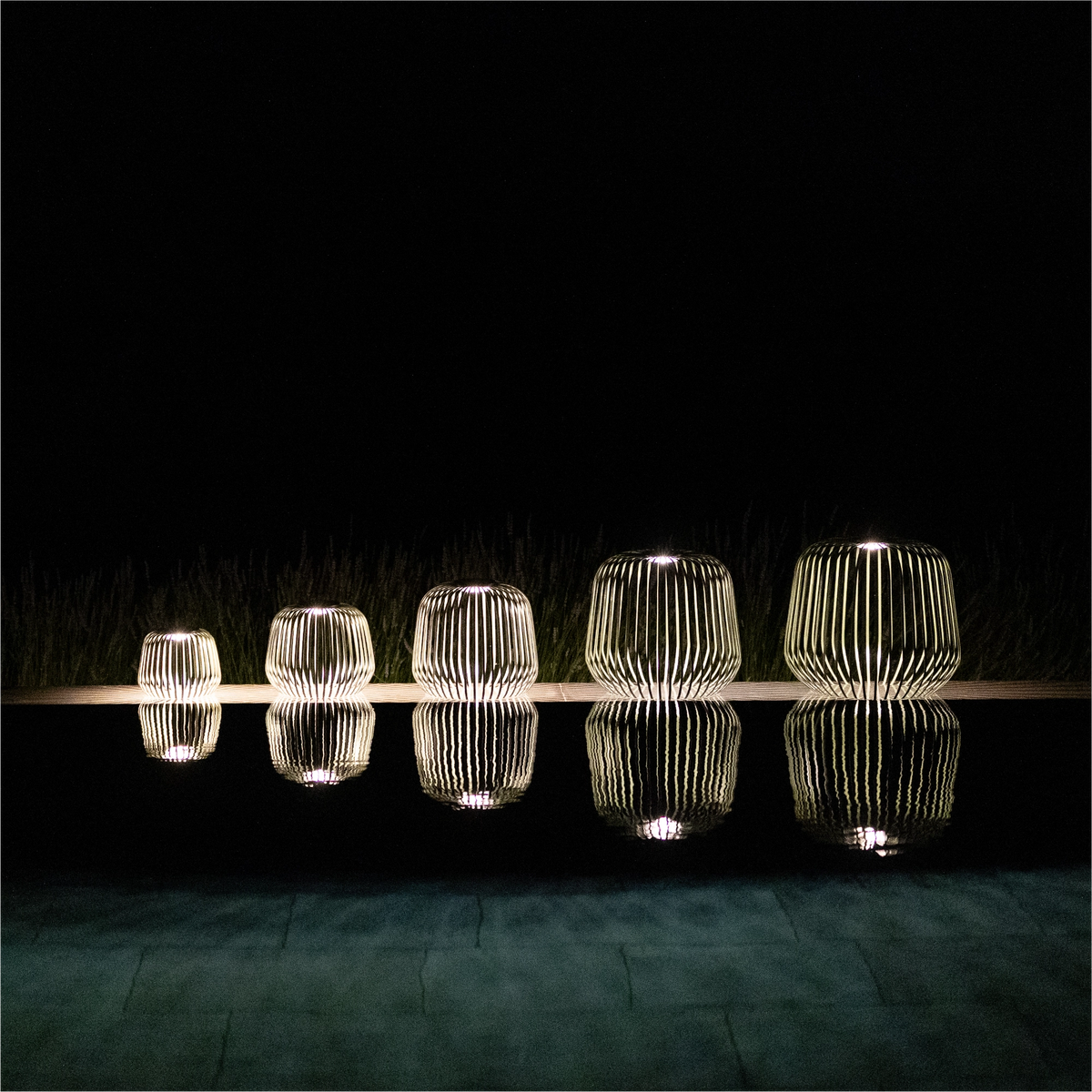 5er Set SOLIS von LUUK Studio in den Größen S, M, L, XL, XXL in Waldgrün bei Nacht mit Spiegelung im Pool