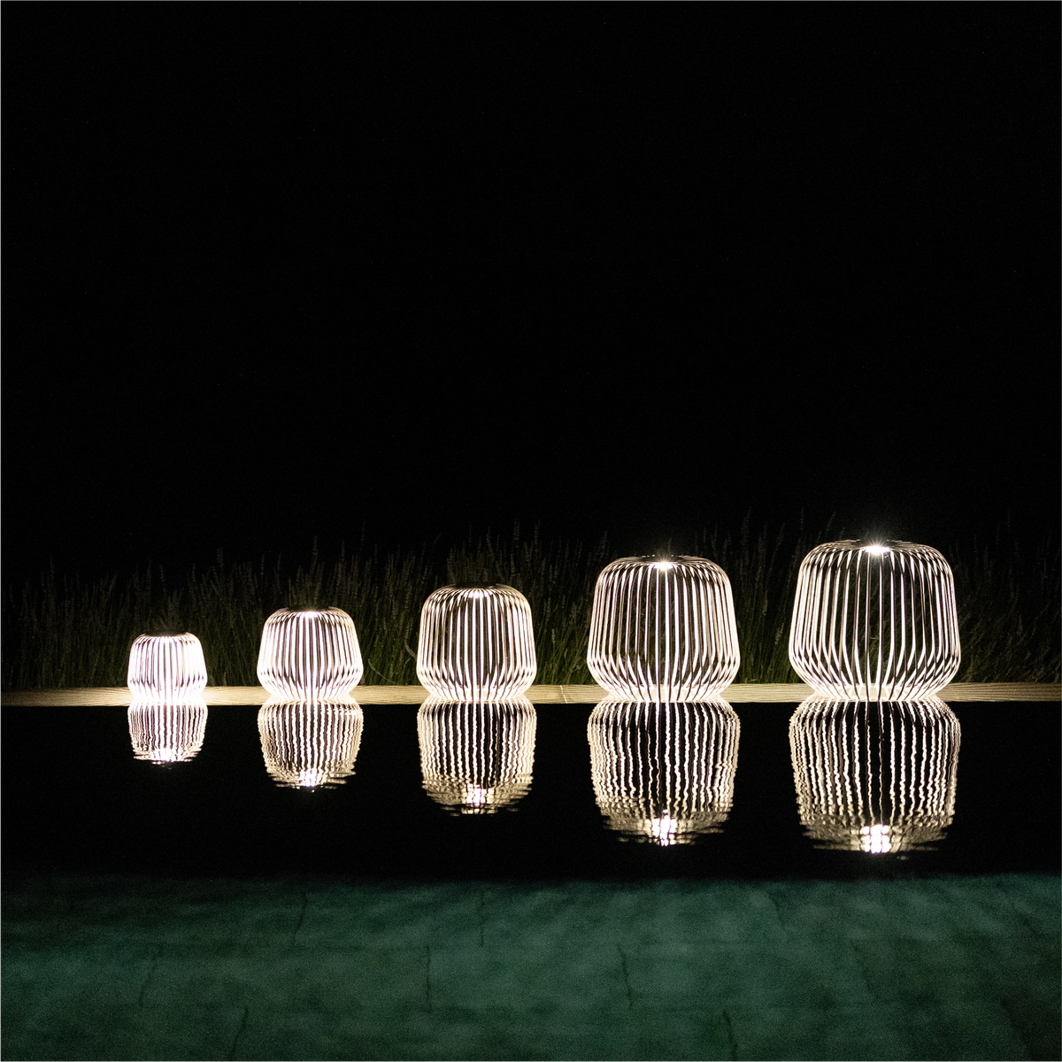5er Set SOLIS von LUUK Studio in den Größen S, M, L, XL, XXL in Nomad bei Nacht am Pool mit Spiegelung im Wasser