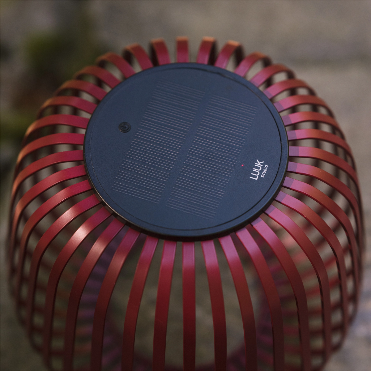 Solarleuchte SOLIS von oben in Kirschrot mit sichtbaren Solarmodul und Logo von LUUK Studio